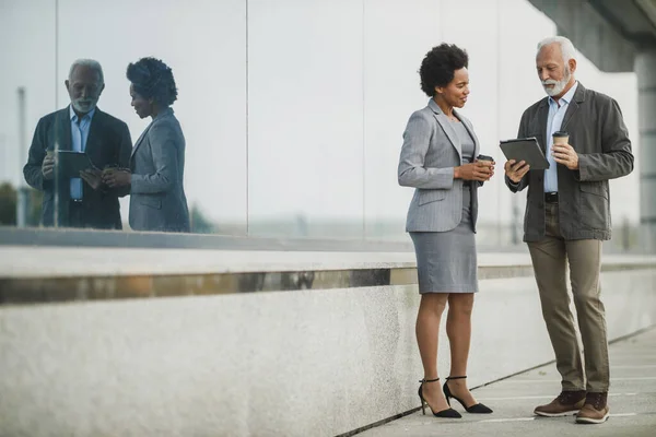 Съемка Двух Успешных Многонациональных Бизнесменов Говорящих Использующих Цифровые Планшеты Время — стоковое фото