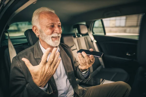Skjuten Framgångsrik Senior Man Som Använder Smartphone När Sitter Baksätet — Stockfoto