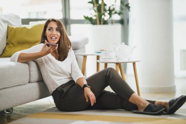 Çekici genç bir kadın evinde boş zaman geçiriyor ve akıllı bir telefondan sesli mesaj konuşuyor..