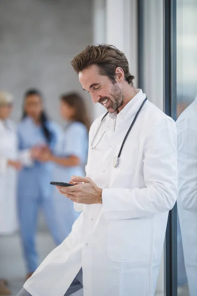 Ein Lächelnder Arzt Surft Auf Seinem Smartphone Netz Während Während — Stockfoto