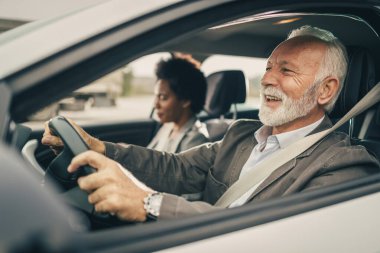 Arabayla seyahat eden iki başarılı çoklu etnik iş adamının fotoğrafı..