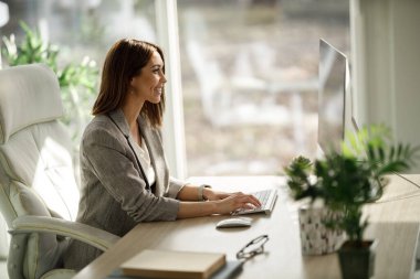 Çekici bir iş kadını evinde tek başına oturup bilgisayarla çalışıyor..