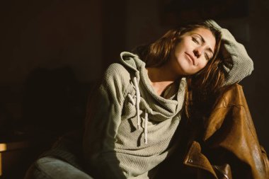 Çekici genç bir kadın dinleniyor ve güneşli bir sabahın tadını çıkarıyor..