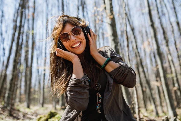 Een Glimlachende Jonge Vrouw Die Muziek Luistert Haar Koptelefoon Terwijl — Stockfoto