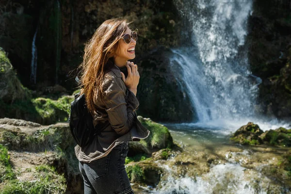 Seorang Wanita Muda Yang Ceria Menikmati Pemandangan Air Terjun Yang — Stok Foto