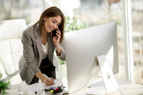 Uma Mulher Negócios Sucesso Falando Smartphone Enquanto Trabalhava Mesa Seu — Fotografia de Stock