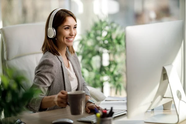 Een Aantrekkelijke Zakenvrouw Zit Alleen Haar Kantoor Met Een Koptelefoon — Stockfoto