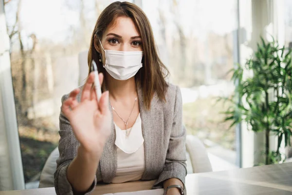 Een Aantrekkelijke Jonge Vrouw Met Chirurgisch Masker Zittend Haar Kantoor — Stockfoto