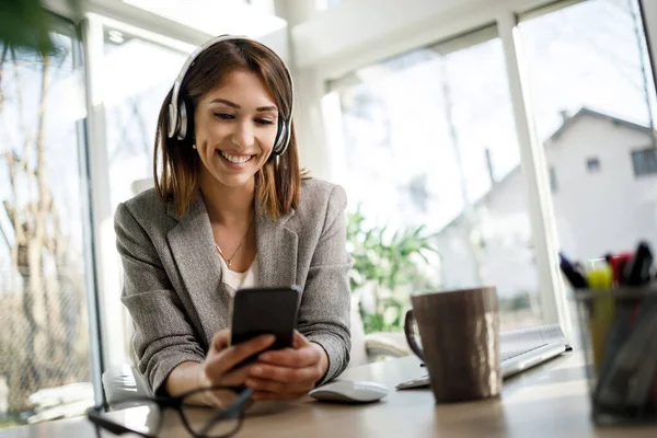 Usmívající Zamyšlená Žena Pomocí Smartphonu Při Práci Své Domácí Kanceláři — Stock fotografie