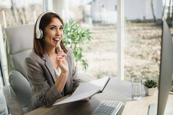 Una Mujer Negocios Sonriente Con Auriculares Pensando Mientras Trabaja Computadora — Foto de Stock