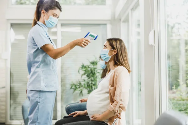 Enfermera Midiendo Temperatura Una Joven Embarazada Sala Espera Durante Pandemia —  Fotos de Stock