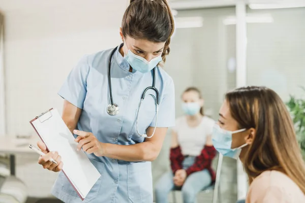 Νοσοκόμα Που Μιλάει Νεαρή Γυναίκα Πριν Εμβόλιο Covid Στην Αίθουσα — Φωτογραφία Αρχείου