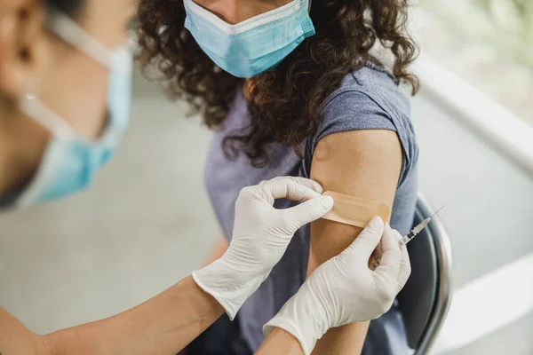 코로나 바이러스 대유행으로 백신을 접종받은 간호사가 아프리카 미국인 소녀에게 밴드를 — 스톡 사진