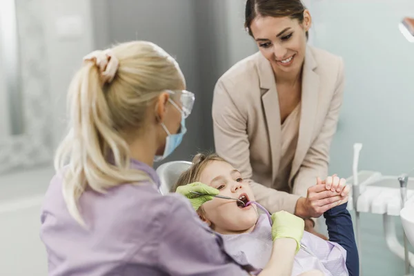 一个可爱的小女孩和她妈妈在牙科诊所接受牙医检查 — 图库照片