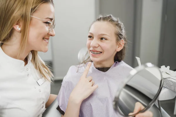 Uma Adolescente Feliz Olhando Seus Dentes Espelho Após Procedimento Dentário — Fotografia de Stock