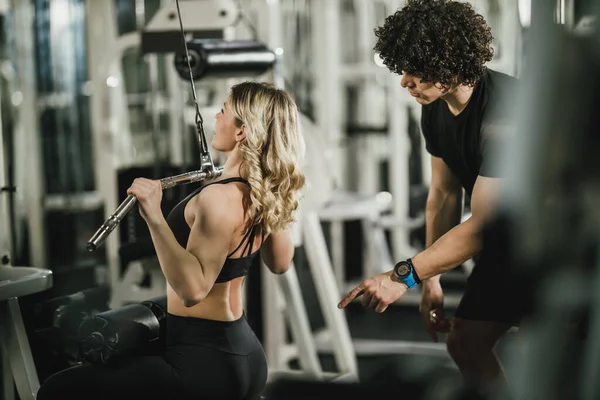 Una Joven Musculosa Está Haciendo Entrenamiento Máquina Apoyo Por Entrenador —  Fotos de Stock