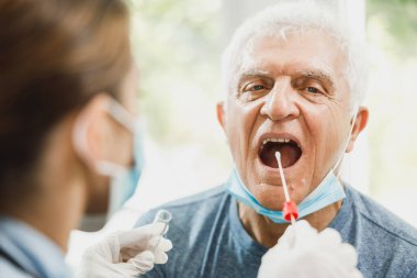 Coronavirus salgını sırasında boğazından örnek alan yaşlı bir adam..