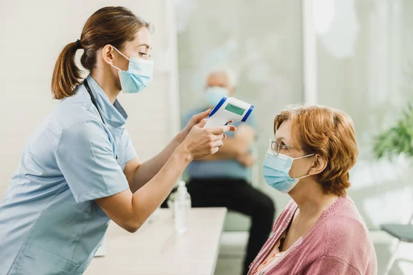 Oudere Vrouw Met Een Gezichtsmasker Die Haar Temperatuur Heeft Laten — Stockfoto