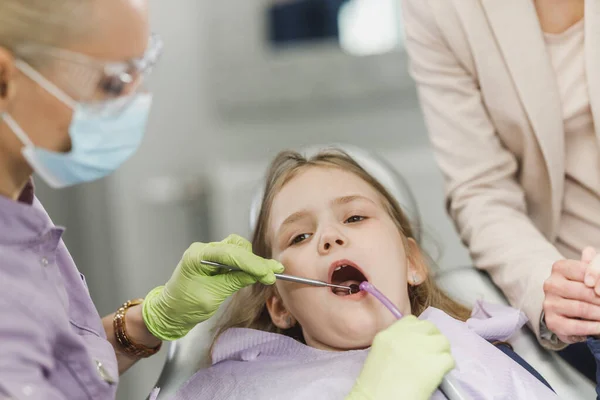 一名女牙医在牙科诊所检查可爱的小女孩的牙齿 — 图库照片