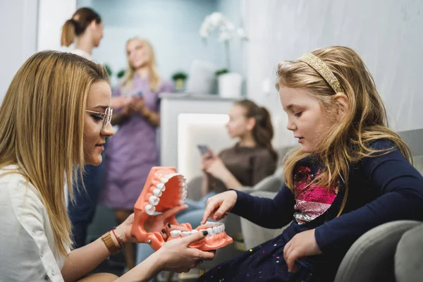 Οδοντίατρος Και Κοριτσάκι Που Κρατούν Μοντέλο Των Δοντιών Και Επικοινωνούν — Φωτογραφία Αρχείου