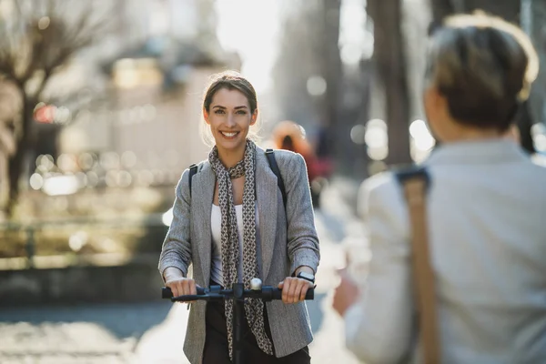 若いビジネスの女性が電動プッシュスクーターで仕事に行く — ストック写真