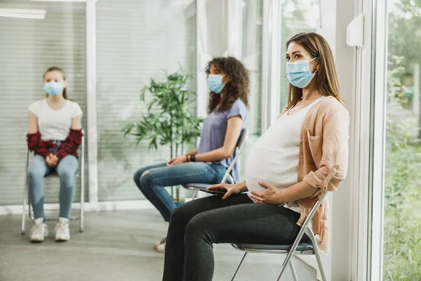 Jonge Zwangere Vrouw Met Een Gezichtsmasker Zitten Een Wachtkamer Wachten — Stockfoto