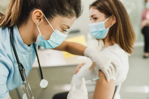 코로나 바이러스 유행병으로 여성에게 백신을 투여하는 간호사 — 스톡 사진