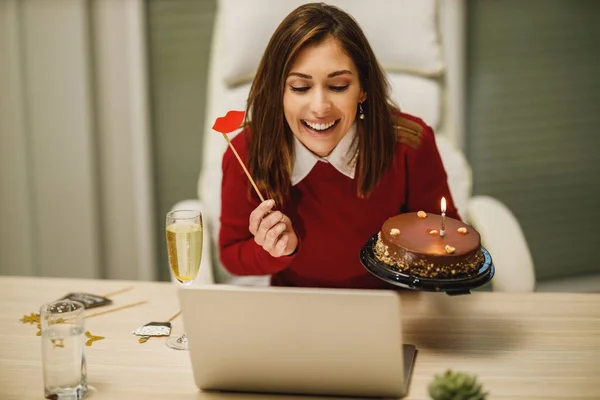 Uśmiechnięta Atrakcyjna Kobieta Trzymająca Tort Urodzinowy Mająca Internetową Imprezę Przyjaciółmi — Zdjęcie stockowe