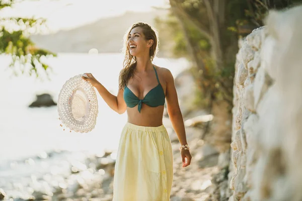 若い幸せな女性は夏の日にビーチで散歩に行く — ストック写真