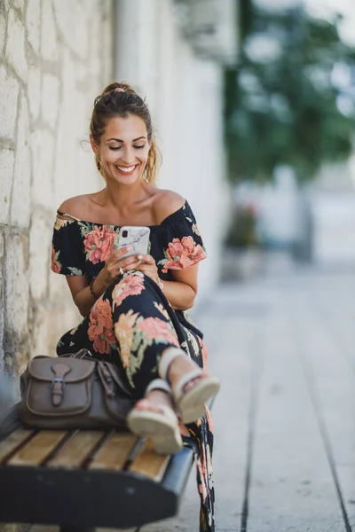 Mladá Usměvavá Žena Sedící Lavičce Surfující Sociální Média Svém Smartphonu — Stock fotografie
