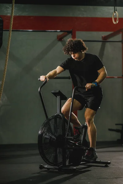 Joven Musculoso Está Haciendo Entrenamiento Duro Crossfit Bicicleta Gimnasio —  Fotos de Stock