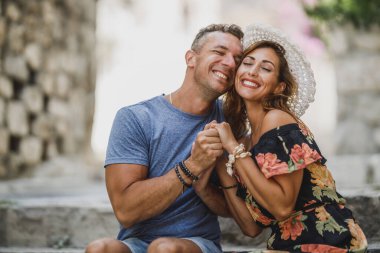 Mutlu çift merdivenlerde oturuyor ve Akdeniz 'de yaz tatilinin tadını çıkarıyor..