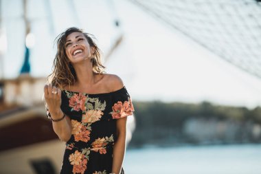 Genç ve neşeli kadın yaz tatilini sahilde geçirirken eğleniyor ve eğleniyor..