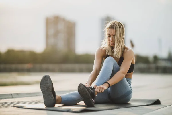 Uma Jovem Esportiva Amarrando Seus Atacadores Enquanto Exercita Livre — Fotografia de Stock