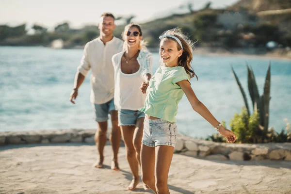 夏休みを楽しみながら海の近くを歩いている10代の女の子と笑顔の家族 — ストック写真