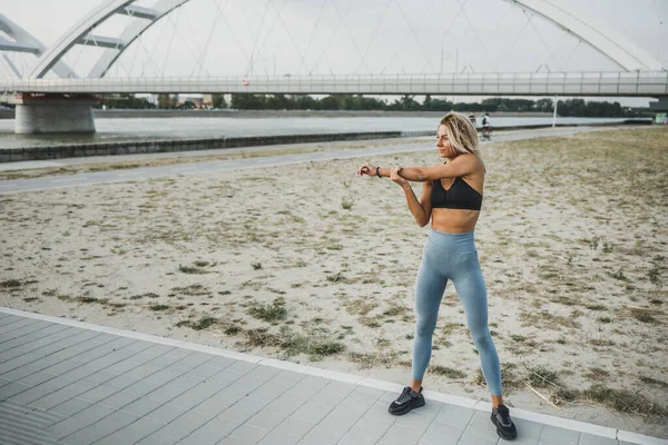 Una Giovane Donna Sportiva Che Scalda Allunga Braccia Mentre Allena — Foto Stock