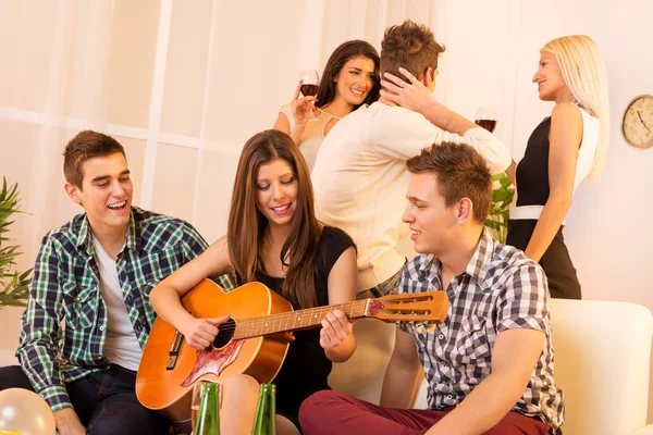 Chica tocando guitarra en casa fiesta — Foto de Stock