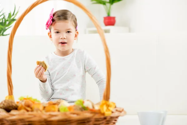 En liten flicka äter bakade produkter — Stockfoto