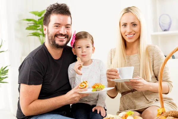 Lycklig familj äter bakelse till frukost — Stockfoto