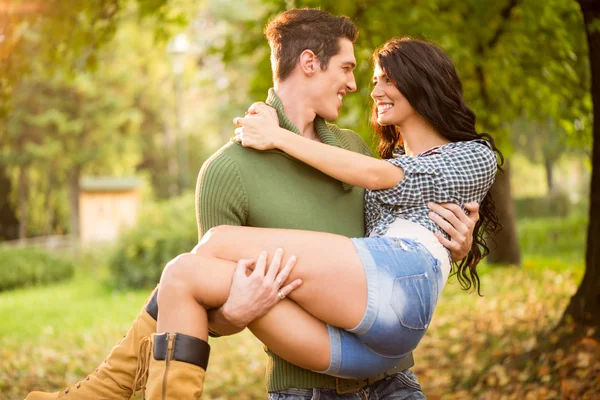 Chico con la chica en sus brazos —  Fotos de Stock