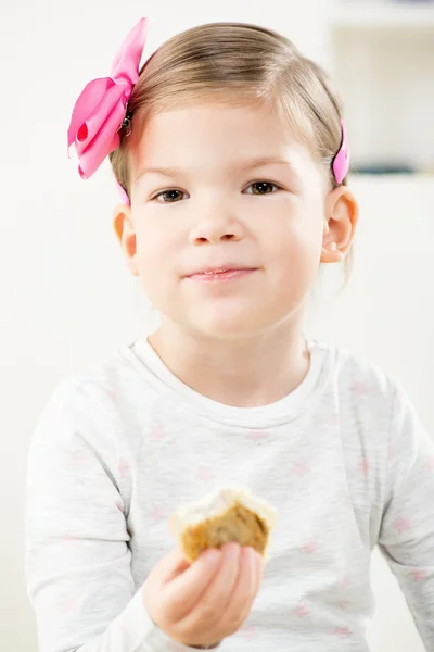 Маленькая девочка ест пирожные — стоковое фото