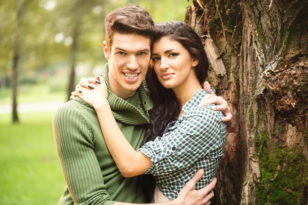 Pareja abrazada junto al árbol — Foto de Stock