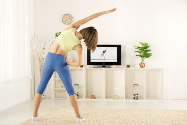 Exercício de menina, assistindo TV — Fotografia de Stock