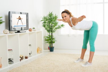 Genç kadın esneme egzersizleri yapıyor. 