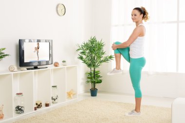 Genç kadın esneme egzersizleri yapıyor. 