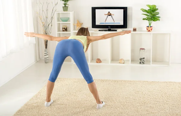 Mulher Exercício na frente da TV — Fotografia de Stock