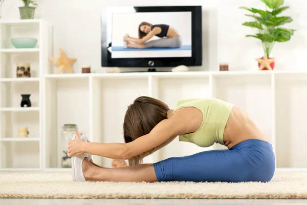 Woman Stretching In Front Of TV — Stock Photo, Image