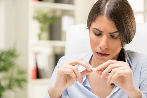 Mujer joven toma una píldora — Foto de Stock