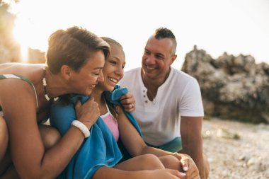 Anne kızını kucaklarken neşeli aile sahilde birlikte eğleniyor.. 