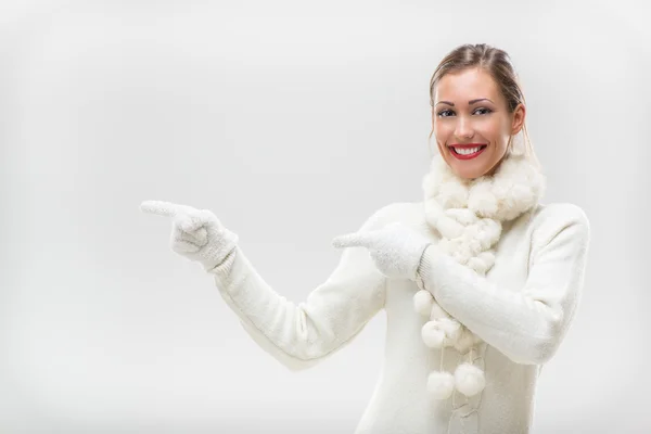 Menina em roupas de inverno apontando para longe — Fotografia de Stock